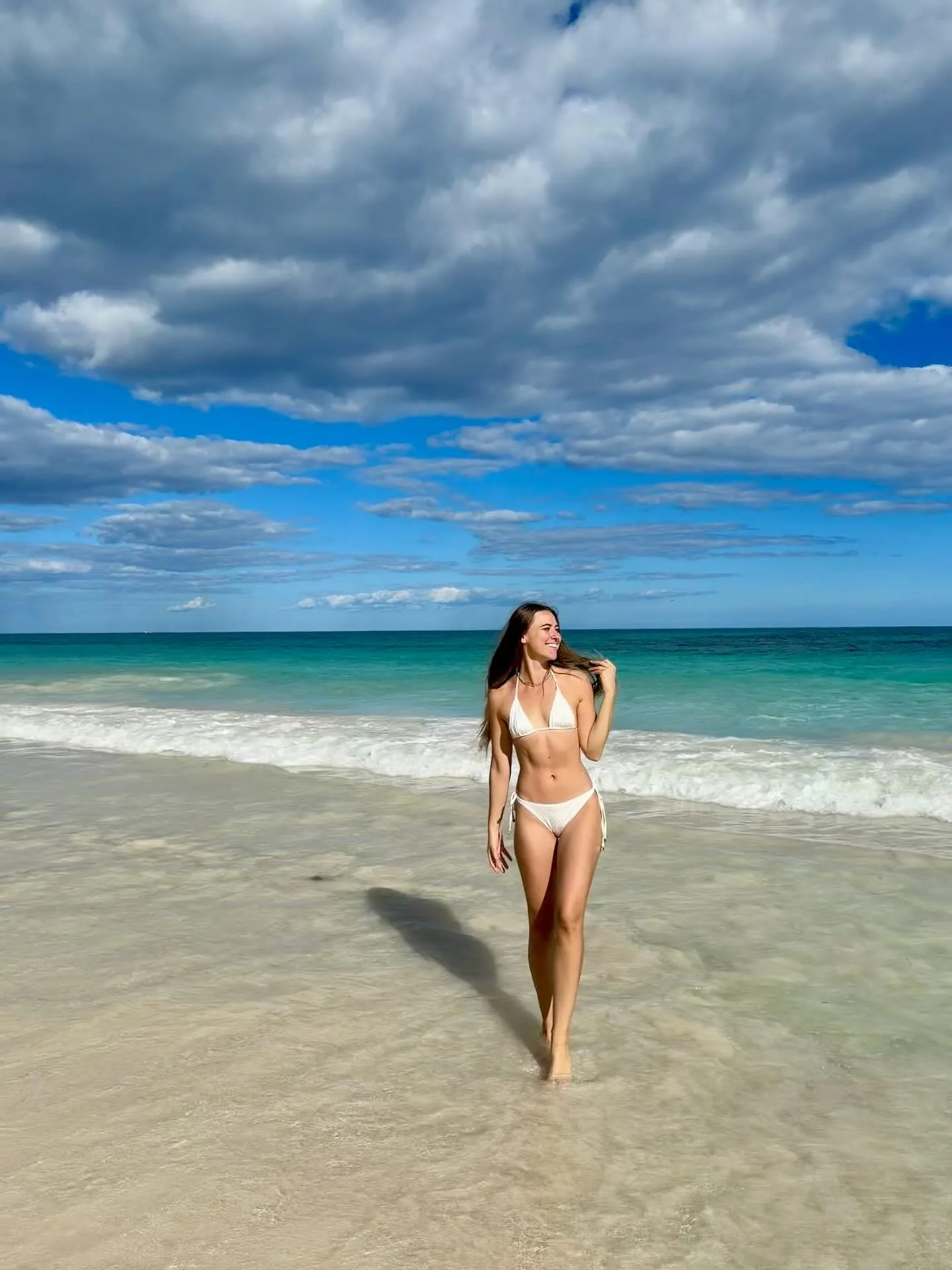 Lana walking on a turquoise tropical beach
