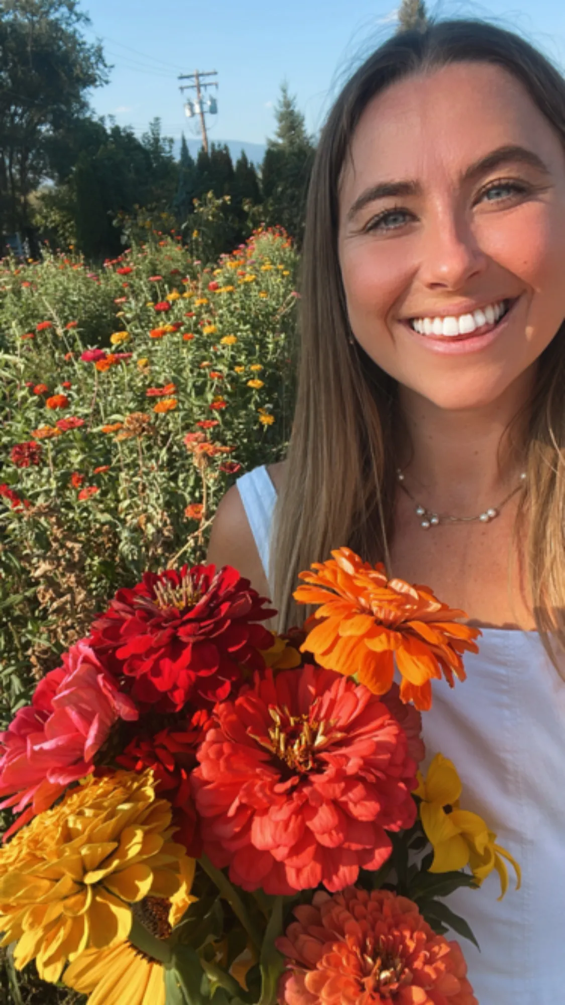 Lana smiling in golden light with colorful flowers